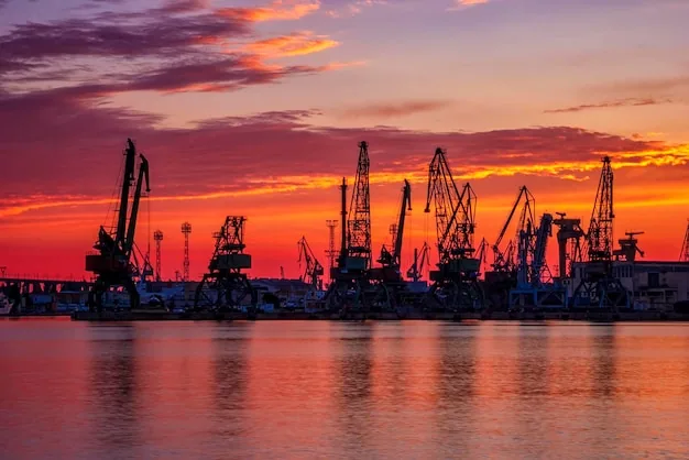 Port cranes silhouetted against a dusk sky